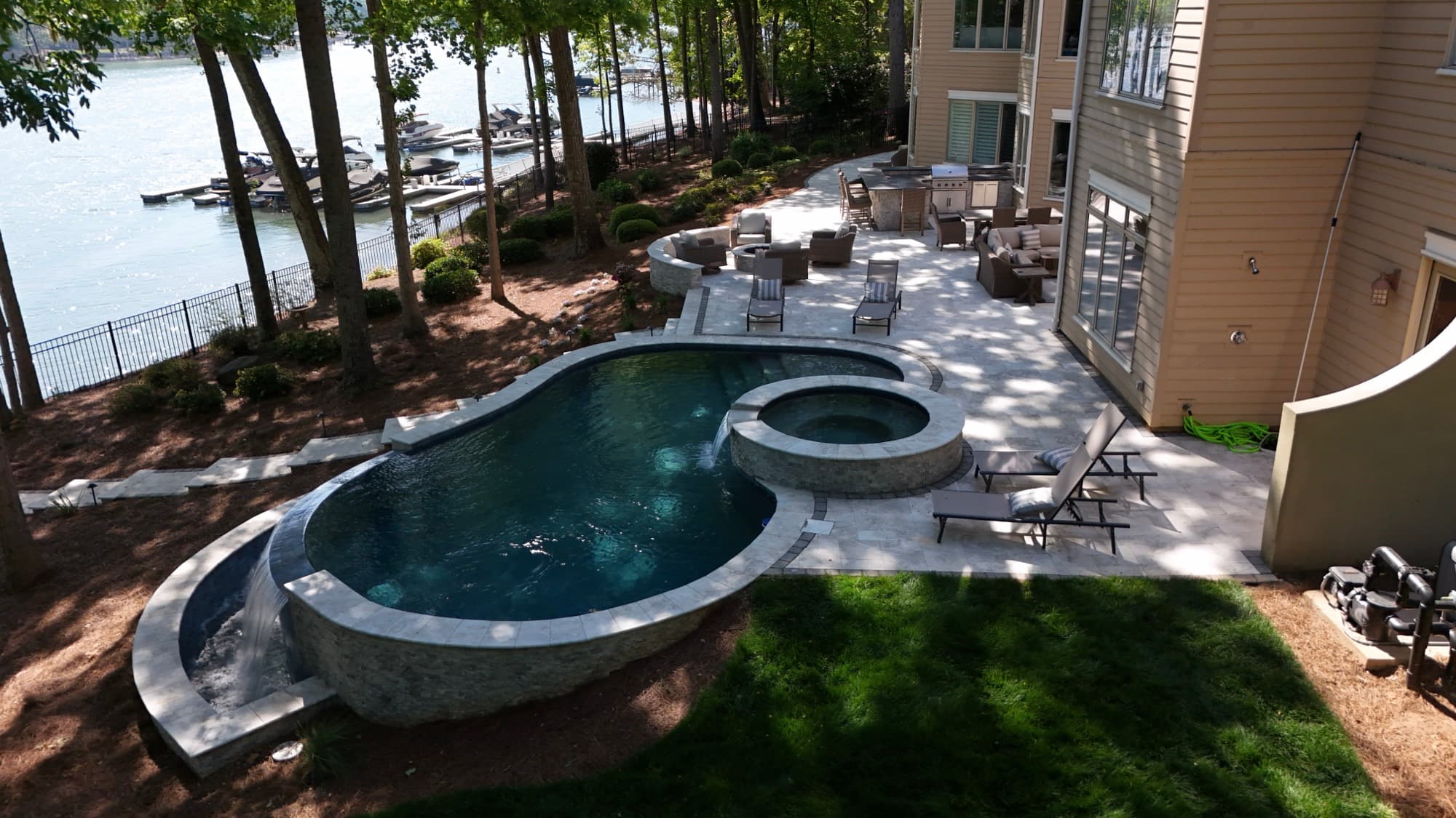 Real estate aerial of a lakefront luxury home with pool and private dock by SQO SkyWorks, Charlotte NC