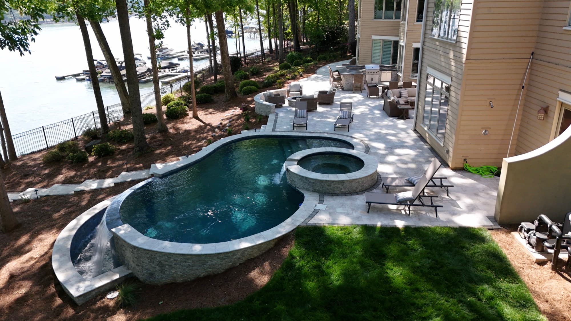 Aerial real estate photo of a waterfront home with pool and patio by SQO SkyWorks, Charlotte NC