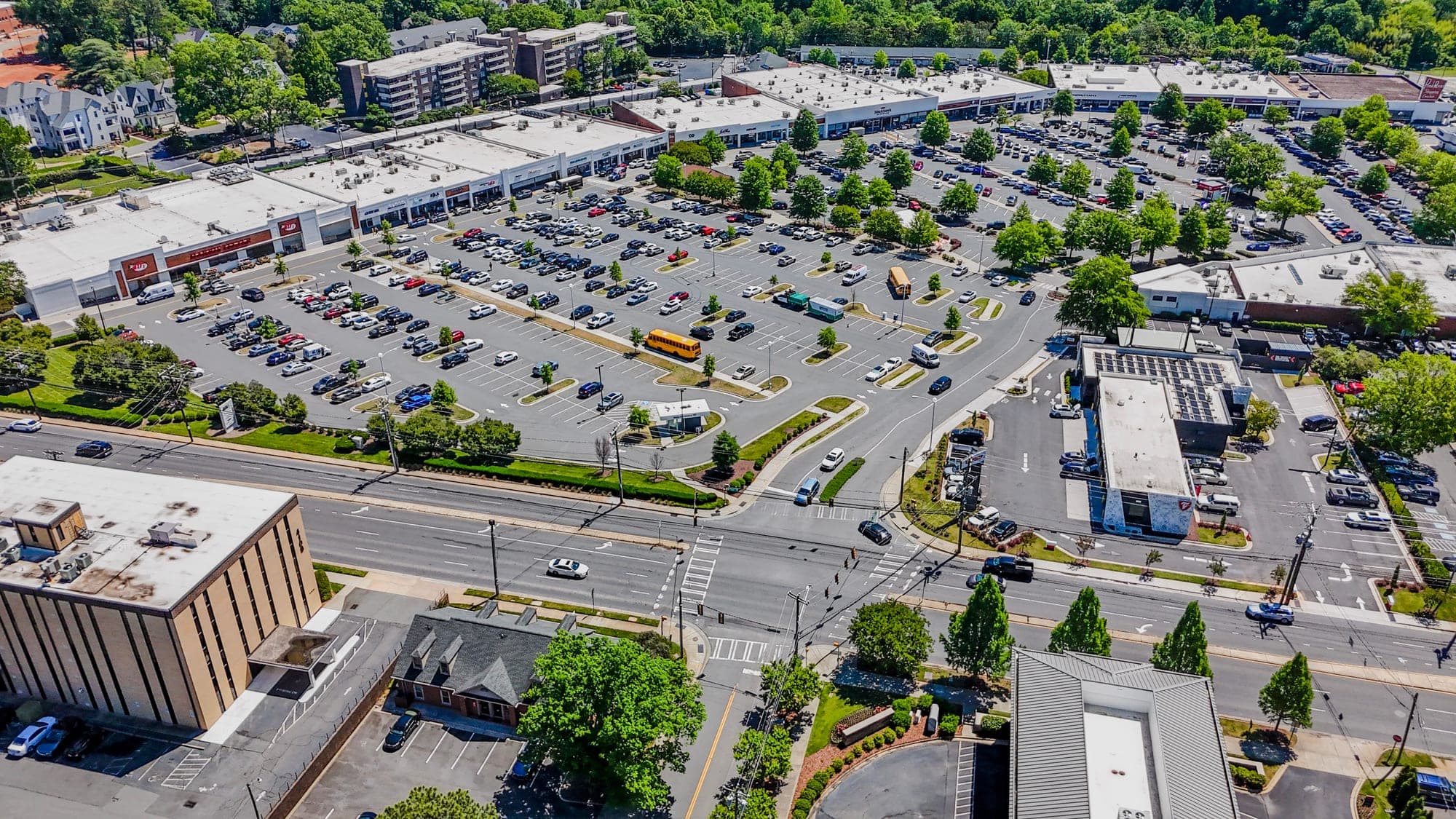 Sweeping aerial of a multi-tenant commercial complex with extensive parking