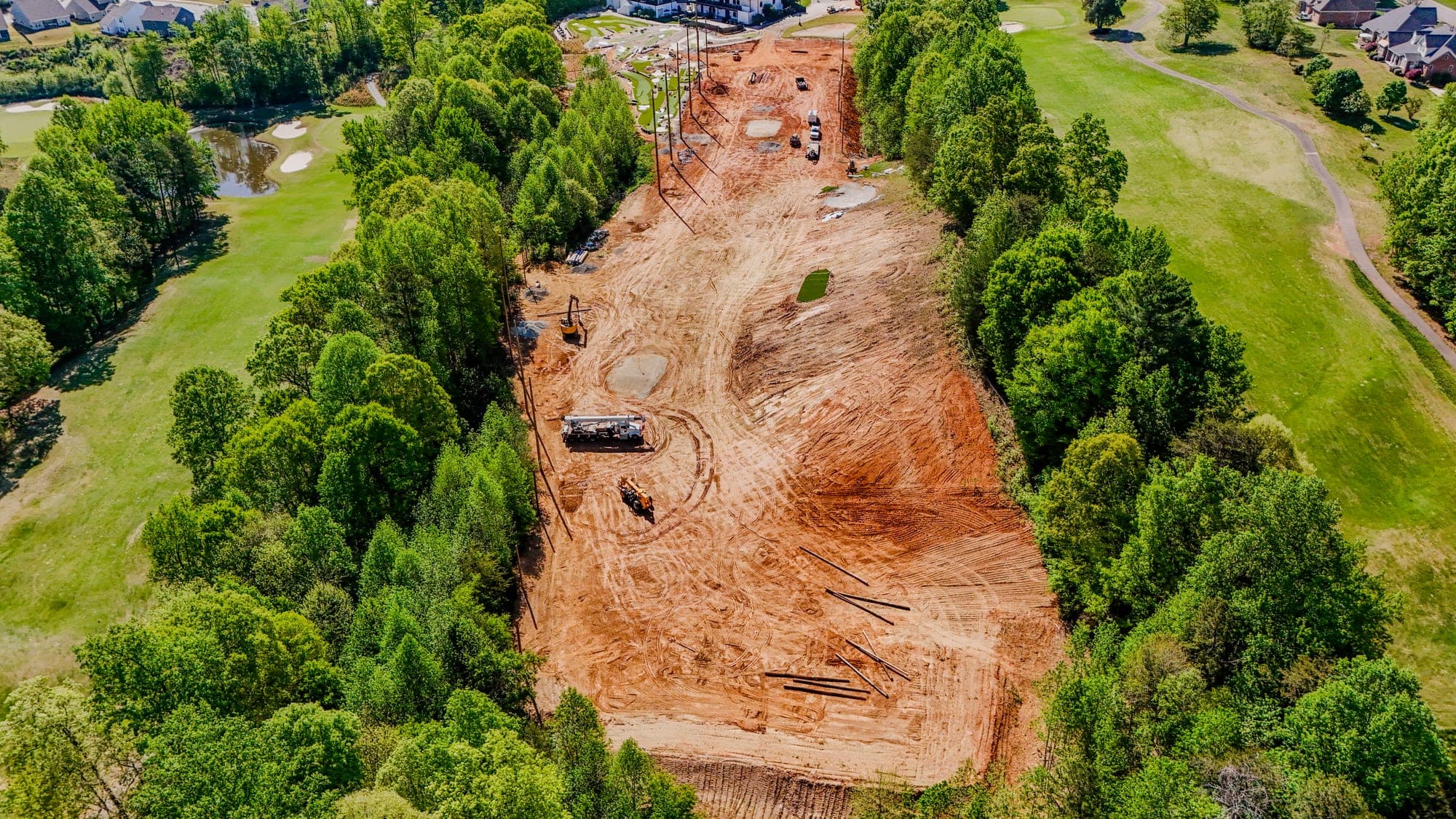 Aerial drone photo of site clearing and earthwork with machinery on red Carolina clay