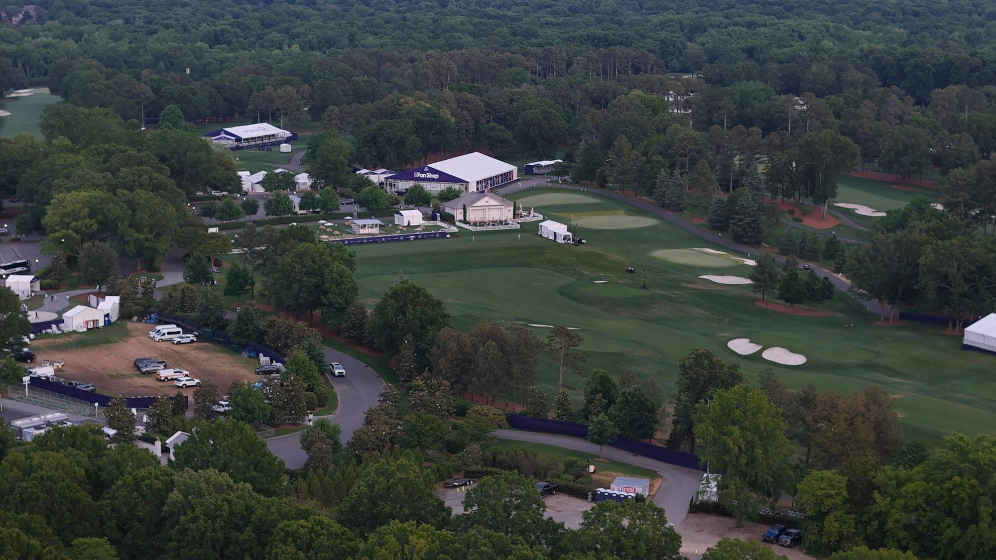 Aerial drone photo of an outdoor event with tents set up on a golf course