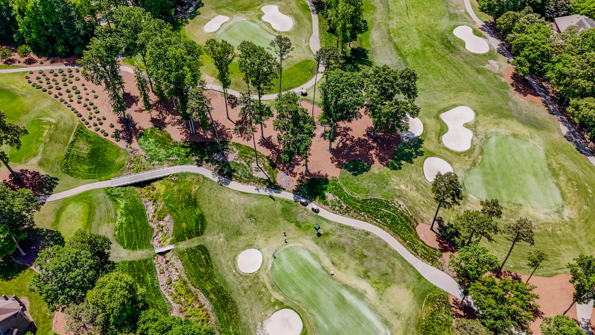 Scenic aerial of a golf course and creek crossing by SQO SkyWorks, Charlotte NC