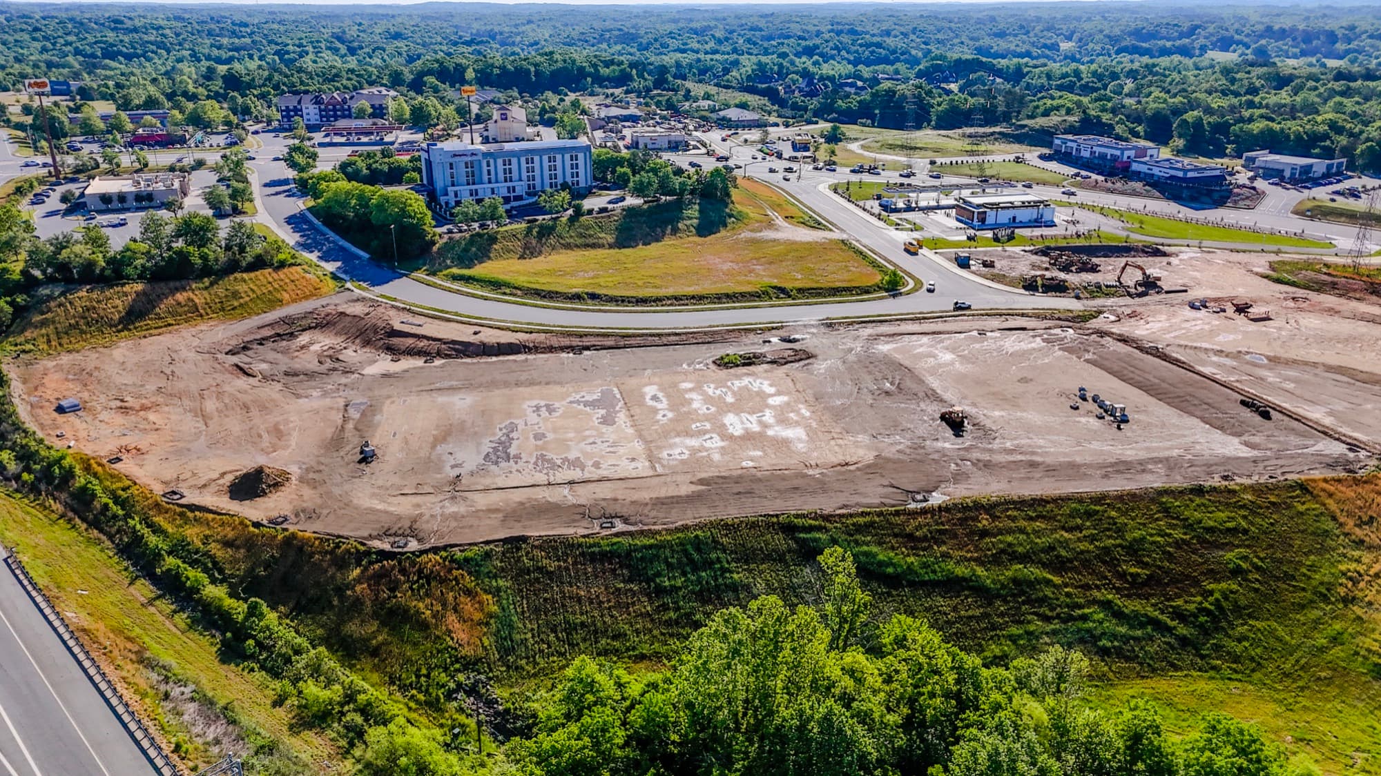 Aerial overview of a graded site beside existing commercial buildings by SQO SkyWorks, Charlotte NC
